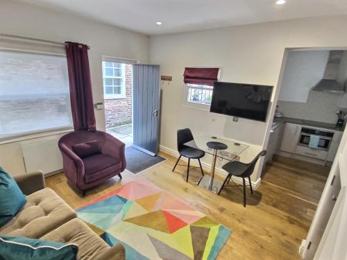 a living room with a couch and a table and chairs at Bootes Cottage in York