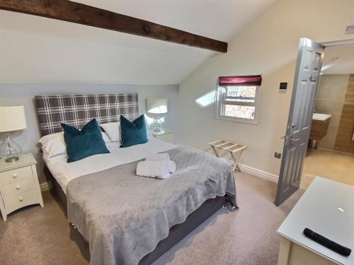 a bedroom with a large bed with blue pillows at Bootes Cottage in York