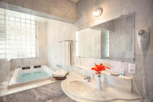 uma casa de banho com um lavatório e uma banheira em Wetiga Hotel em Bonito
