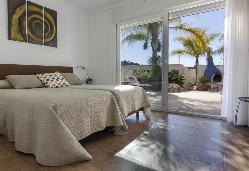 Schlafzimmer mit einem Bett und einer großen Glasschiebetür in der Unterkunft Luxury Xenofilia V in Moraira