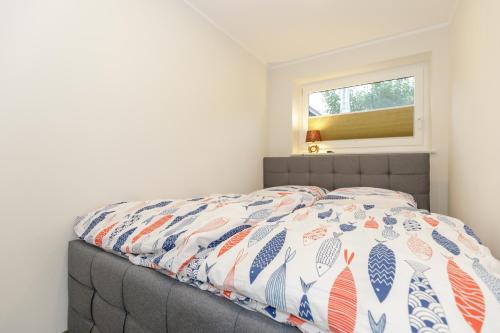 um quarto com uma cama com uma colcha em Fewo Hafenblick em Kühlungsborn