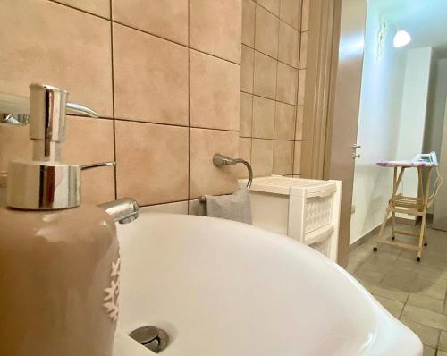 a white bath tub in a bathroom with a chair at Casa Tramonto in Alliste