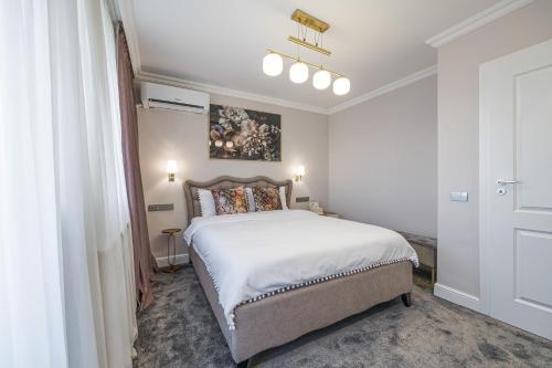 una camera da letto con un grande letto bianco in una stanza di Bright House Cantemir a Bucarest