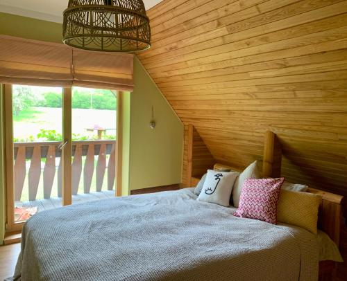um quarto com uma cama e um tecto em madeira em Kastaņas em Kaibala