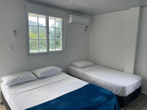 two beds in a room with two windows at Providence Paradise in Providencia