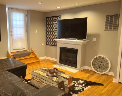 a living room with a fireplace and a flat screen tv at Wrigley 2 bedroom 2 bath with free parking & yard! in Chicago