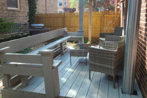 a wooden deck with chairs and a bench at Wrigley 2 bedroom 2 bath with free parking & yard! in Chicago