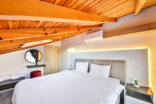 una camera da letto con un grande letto bianco e soffitti in legno di Tuğçe Apart a Kaş