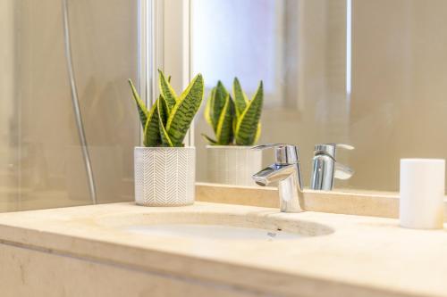 eine Badezimmertheke mit einem Waschbecken und einem Spiegel in der Unterkunft Apartment Aroeira Golf I in Charneca