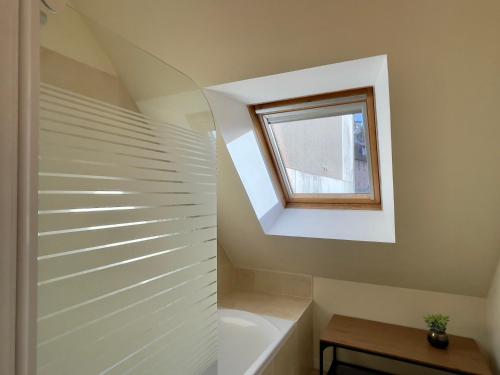 a bathroom with a tub and a window at Le Mulberry in Bayeux