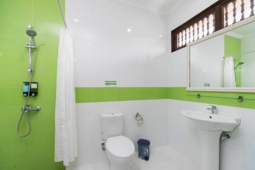 a bathroom with a toilet and a sink at Bali Wirasana Inn in Sanur