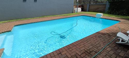 uma grande piscina azul com duas cadeiras em Sanche 9 em Freeland Park