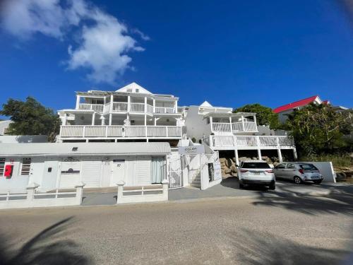 a large white building with cars parked in front of it at 5 min d'Orient bay-vue imprenable, Idolem résidence unité 8 - 57 Rue du Mont Vernon 1 in Cul de Sac