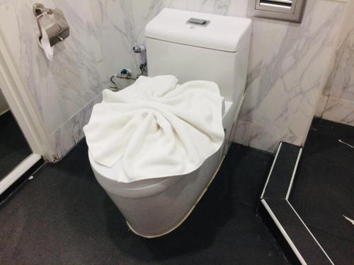 a toilet in a bathroom with a skateboard on it at Siam Best Inn in Makkasan