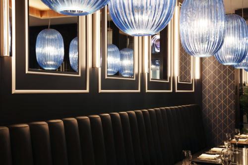 a dining room with blue chandeliers on the wall at Hotel Reykjavík Saga in Reykjavík