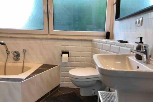 uma casa de banho com um WC, um lavatório e uma janela em Gemütliches Bergappartement mit Weitblick em Bad Bentheim