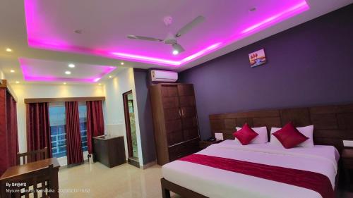 a bedroom with a bed with pink lights on the ceiling at Coorg ASHOK PALACE in Madikeri