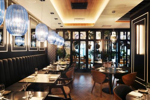 a restaurant with tables and chairs and lights at Hotel Reykjavík Saga in Reykjavík