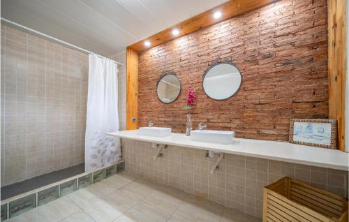 a bathroom with two sinks and a brick wall at Stunning Home In St Andreu D,llavaneres With 4 Bedrooms, Wifi And Outdoor Swimming Pool in Sant Andreu de Llavaneres