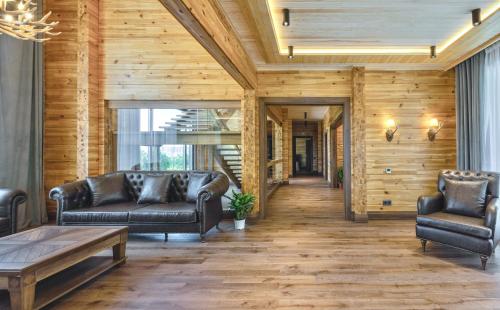 a living room with leather furniture and wooden walls at Eco Village in Samarkand