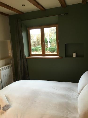 une chambre avec un lit blanc et une fenêtre dans l'établissement Farmhouse B&B, à Saint-Georges