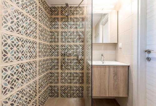 uma casa de banho com um chuveiro e um lavatório. em #FLH - Nereus & Oceanus Beachfront Apartments, Lagonisi Beach em Ormos Panagias