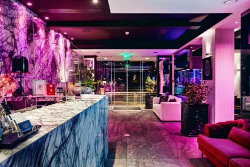 a lobby with a bar with purple lighting at The Ciao Stelio Deluxe Boutique Hotel - Adults Only in Larnaka