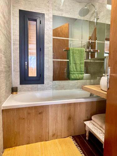 La salle de bains est pourvue d'une baignoire et d'une serviette verte. dans l'établissement Chalet cosy dominant le village, à Lus-la-Croix-Haute