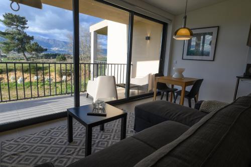 a living room with a couch and a large window at Laje da Bica Agroturismo in Covilhã
