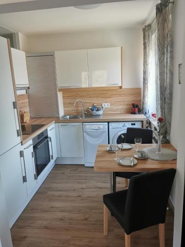 uma cozinha com armários brancos e uma mesa de madeira em HomeW4 - Rosen Apartment em Hoheneich