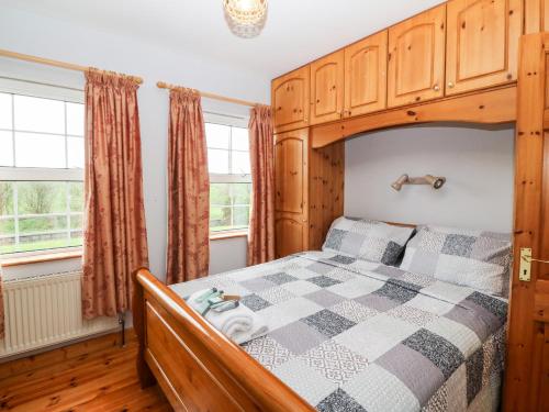 a bedroom with a bed with a wooden bed frame at Raheen in Castletownshend