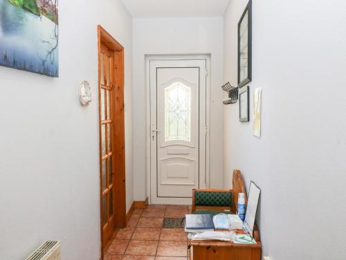 a hallway with a door and a chair and a table at Raheen in Castletownshend