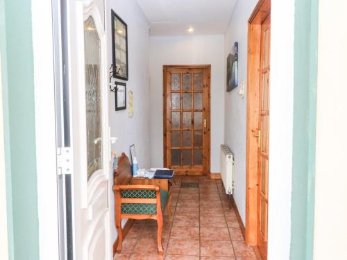 a hallway with a wooden door and a chair at Raheen in Castletownshend