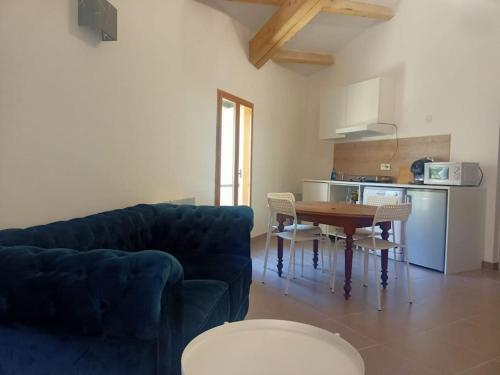 ein Wohnzimmer mit einem blauen Sofa und einem Tisch in der Unterkunft Le clos du pin in Thèzan-lès-Béziers