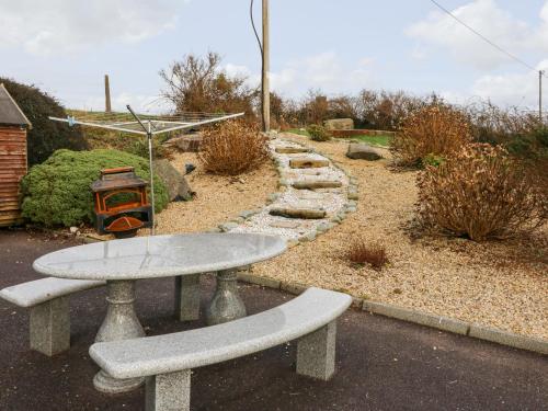 a table and benches in a garden with a path at Raheen in Castletownshend