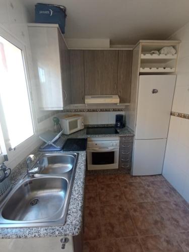 małą kuchnię ze zlewem i lodówką w obiekcie Apartment in La Zenia w mieście Orihuela Costa