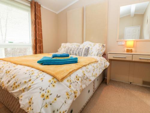 - une chambre avec un lit et des serviettes bleues dans l'établissement Rosie's Chalet, à Carlisle