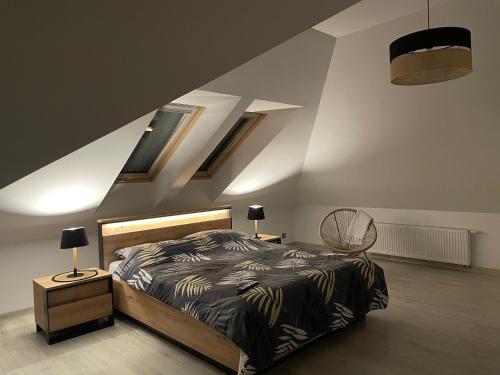 a bedroom with a bed and a staircase with skylights at Pogodna Zagroda-Dom na Kaszubach & Strefa Spa in Kościerzyna