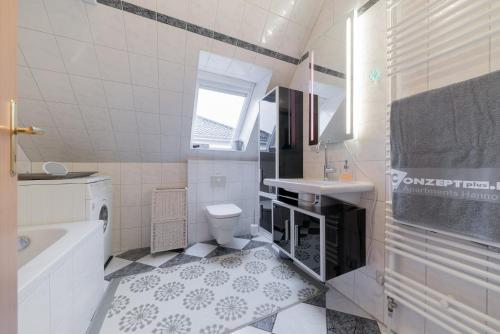 a bathroom with a toilet and a sink and a tub at Privatapartment in Laatzen