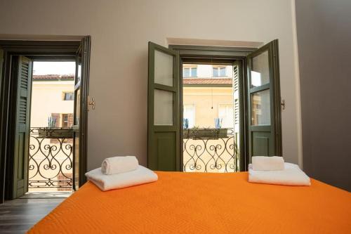an orange bed with two white towels on top of it at Appartamento Roma 55 in Mantova