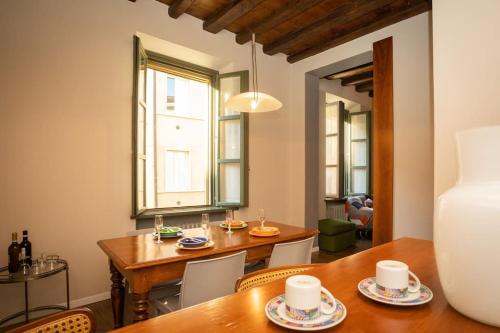 una sala da pranzo con tavolo, sedie e finestra di Appartamento Roma 55 a Mantova