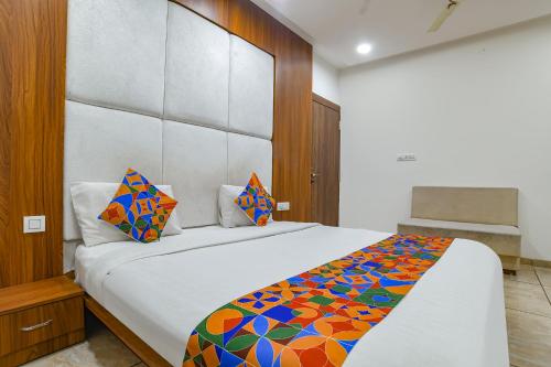 1 dormitorio con 1 cama grande con una manta colorida en FabHotel Right Choice, en Indore