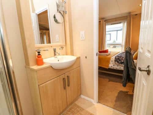 een badkamer met een wastafel en een spiegel bij Rosie's Zen Den in Carlisle