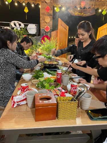 a group of people standing around a table with food at Ninh Binh Royal Homestay in Ninh Binh