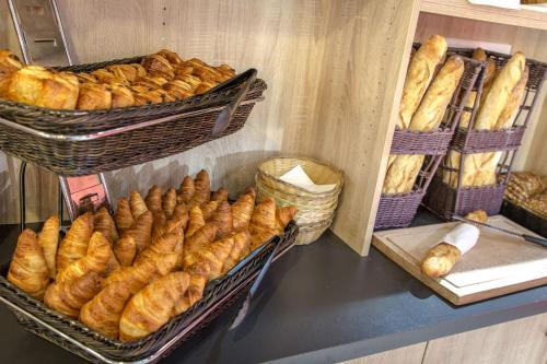 a bunch of loaves of bread in baskets on a counter at SOWELL RESIDENCES Les Sablons in Le Grau-du-Roi