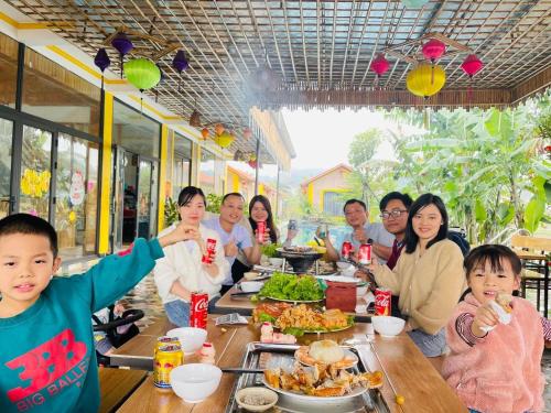 a group of people sitting at a table eating food at Ninh Binh Royal Homestay in Ninh Binh