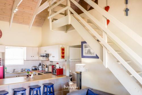a kitchen with white cabinets and blue stools at Little Haven in St Helena Bay