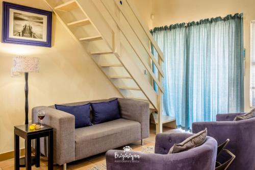 a living room with two couches and a staircase at Little Haven in St Helena Bay