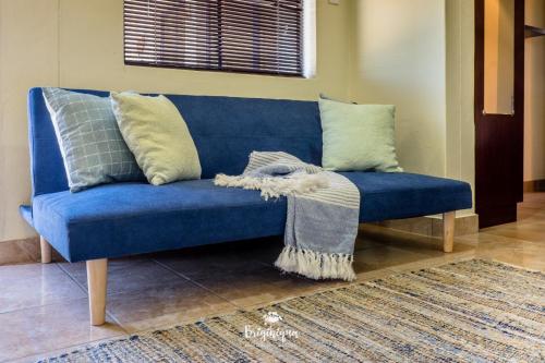 a blue couch with pillows on it in a living room at Little Haven in St Helena Bay