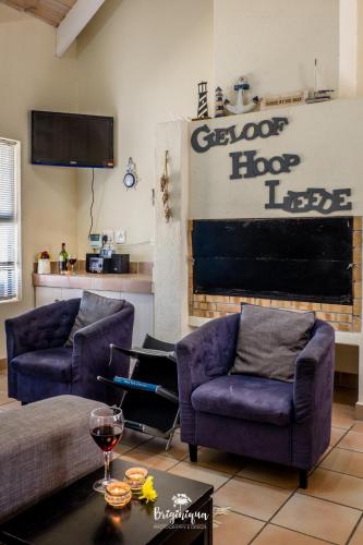 a living room with two purple chairs and a couch at Little Haven in St Helena Bay